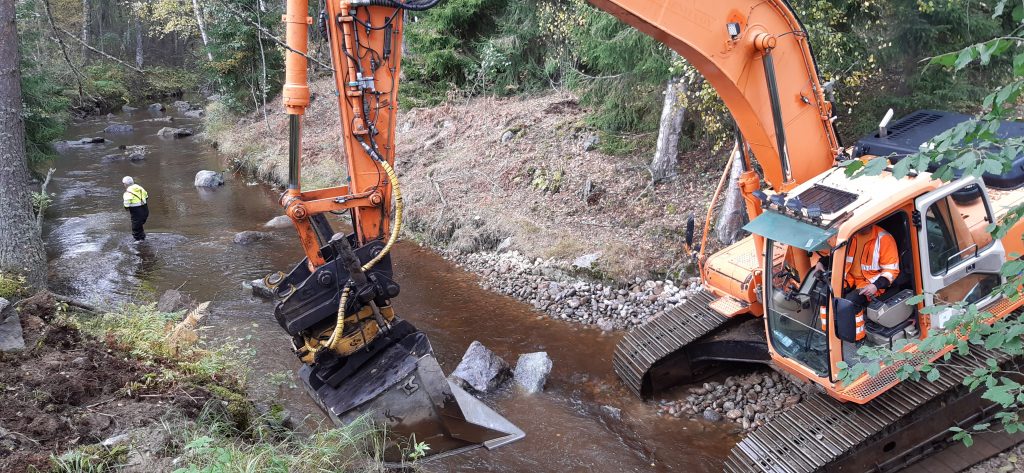 Перемещение камней экскаватором в русле для создания порога
