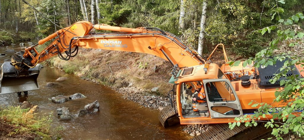 Перемещение камней экскаватором в русле для создания порога
